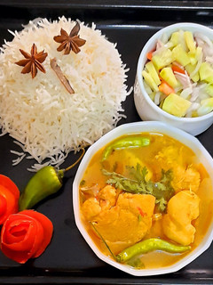 A picture of Chicken gravy and boiled rice with peach drink.