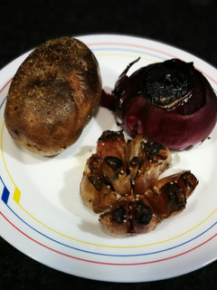 Una foto de Patata, cebolla morada y cabeza de ajo al horno