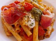 Una foto de pasta al pesto con jamón