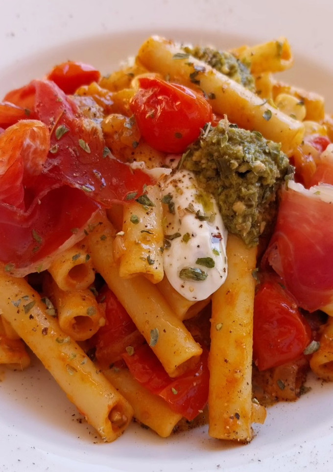 Una foto de Pasta en salsa de queso crema, tomate y pesto