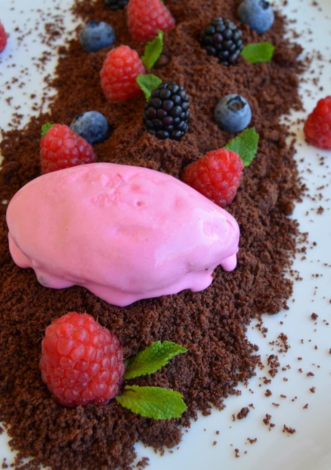 Una foto de Tierra de chocolate con mermelada de frambuesa helado de fresa y frutos rojos