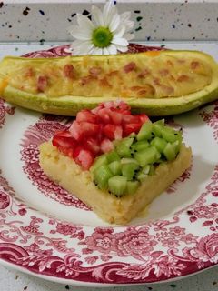 Una foto de Calabacín relleno de jamón y queso con puré de frutas