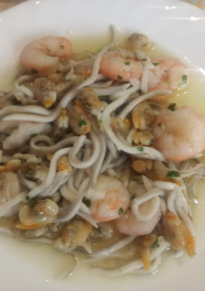 Una foto de Cazuela de gulas con gambas y almejas al ajillo