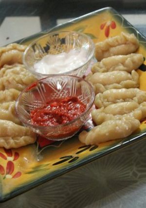 A picture of Vegetable momos with red chilli chutney and mayonnaise.