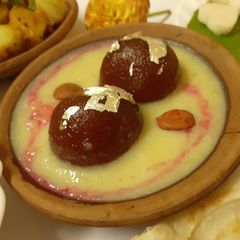 A picture of Gulabjamun in pineapple and rose rabri.