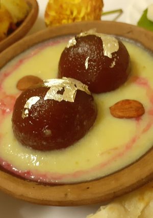 A picture of Gulabjamun in pineapple and rose rabri.
