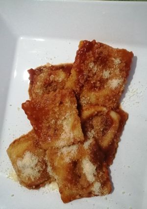 Una foto de Ravioles de jamón y queso/ calabaza y pollo con salsa de tomate