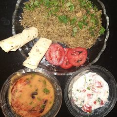 A picture of Spinach rice with dal fry and curd salad.