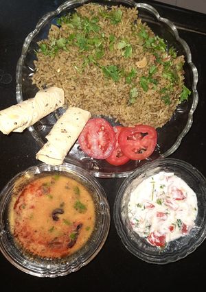 A picture of Spinach rice with dal fry and curd salad.