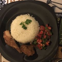 A picture of Boiled Rice,pan fried Mar inated chicken and kachumbari.