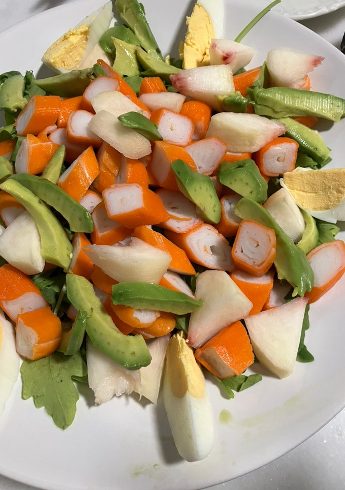 Una foto de Ensalada de rúcula, surimi, paraguaya, aguacate y huevo