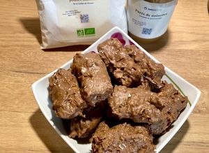 Une photo de Barres protéinées beurre de cacahuète, purée de noisettes Omie, coco, poudre d’amande et chocolat
