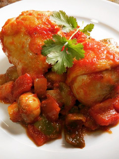 Una foto de Muslos de pollo con salsa de tomate y verduras