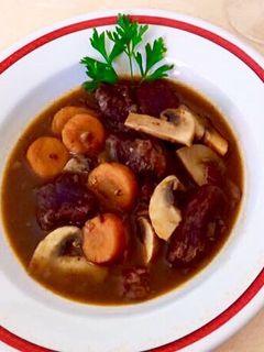 O poză a rețetei Boeuf Bourgouignon..Carne de vițel sau mânzat fiartă molcom cu vin, șalote, ciuperci, șunculiță.