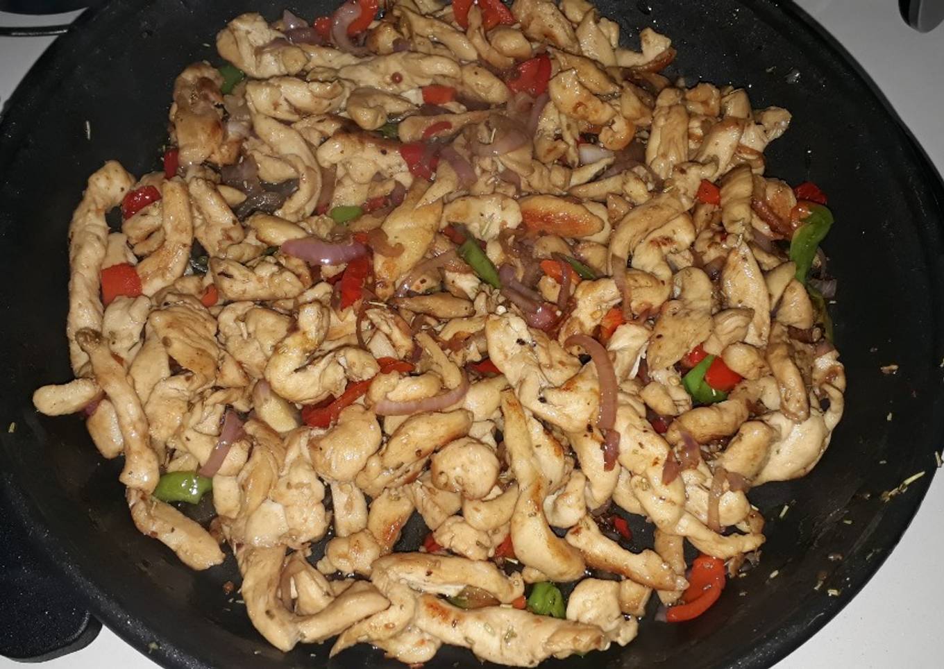 Fajitas de pechuga de pollo salteadas con ají y cebolla