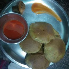 A picture of Palak puri with sauce and pickles.
