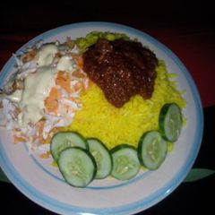Curry Rice and stew, Garnished with cucumber and salad A picture of Curry Rice and stew, Garnished with cucumber and salad.
