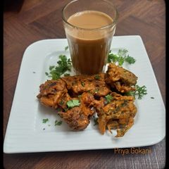 A picture of Pyaaz Hari mirch, dhania ke pakore with adrak wali chai.