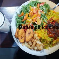 A picture of Fried rice with salad and tigernut drink.