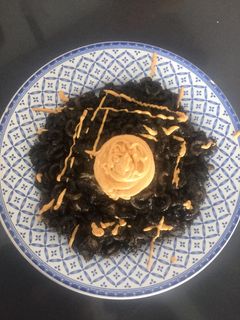 Una foto de Fideuá negra con pulpo y alioli de pimentón