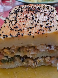 Una foto de Pastel de patatas relleno de gambas con cobertura de bechamel de gambas