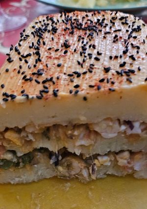 Una foto de Pastel de patatas relleno de gambas con cobertura de bechamel de gambas