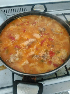 Una foto de Paella de pollo con pimientos verdes, pimientos rojos y cebolla