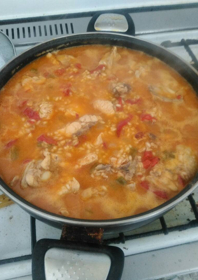 Una foto de Paella de pollo con pimientos verdes, pimientos rojos y cebolla