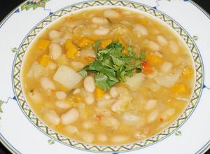 Una foto de Porotos blancos veganos con zapallo y verduras