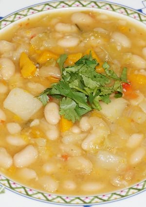 Una foto de Porotos blancos veganos con zapallo y verduras