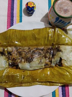 Una foto de Tamal de mole negro con pollo