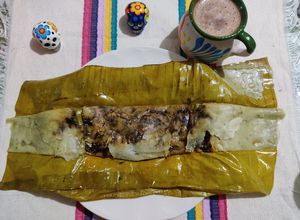 Una foto de Tamal de mole negro con pollo