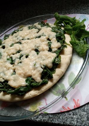 Una foto de Pizza de espinaca salteada con ajo, con salsa blanca de cebolla