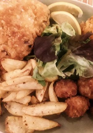 A picture of Breaded pork chop, shrimp and mushrooms.