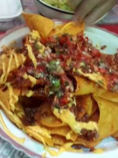 Una foto de Nachos con queso y pico de gallo guacamole