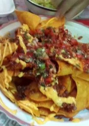 Una foto de Nachos con queso y pico de gallo guacamole