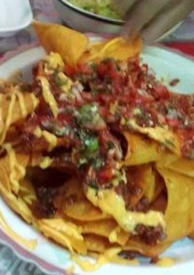 Una foto de Nachos con queso y pico de gallo guacamole