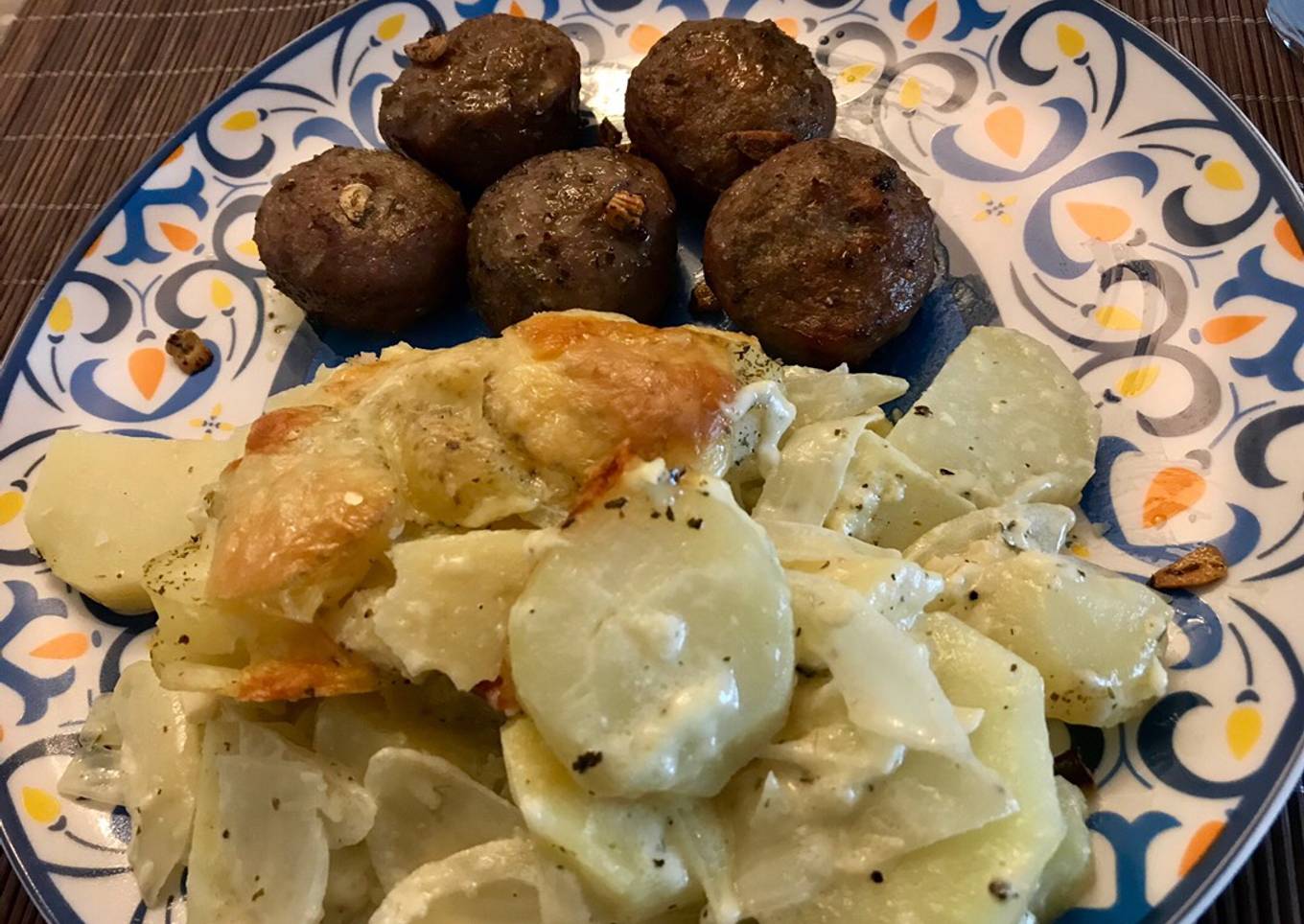 Papas chauchas al gratín con cebolla y queso acompañado de albóndigas