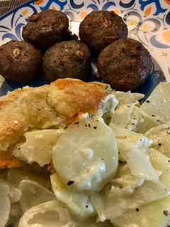 Una foto de Papas chauchas al gratín con cebolla y queso acompañado de albóndigas