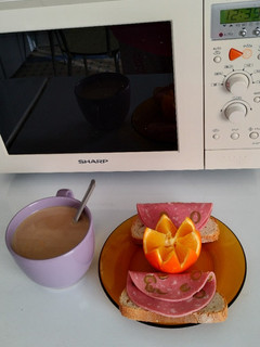Una foto de Desayuno caliente día 8>Café con leche>Pan con mortadela de aceitunas>Naranja de zumo