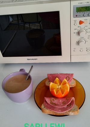 Una foto de Desayuno caliente día 8>Café con leche>Pan con mortadela de aceitunas>Naranja de zumo