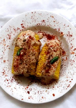 A picture of Corn on the cob in cheese sauce.