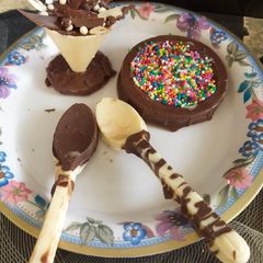 A picture of White Chocolate cup and spoon and milk chocolate filled with sprinkle.