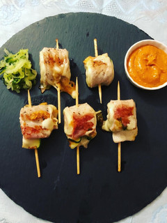 Una foto de Rollitos de cerdo con calabacín y salsa romesco