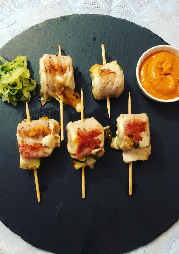 Una foto de Rollitos de cerdo con calabacín y salsa romesco