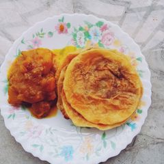 A picture of Bengali lentil stuffed kachori with spicy potato curry.
