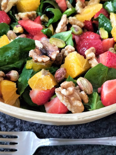 Una foto de Ensalada de espinacas, naranja, fresas y frutos secos