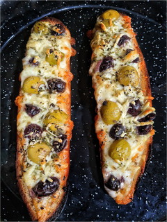 Una foto de Panini con queso y aceitunas