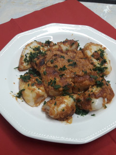 Una foto de Bacalao con calamares y romesco