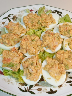 Una foto de Huevos rellenos de ensalada de gambas en cama de lechuga